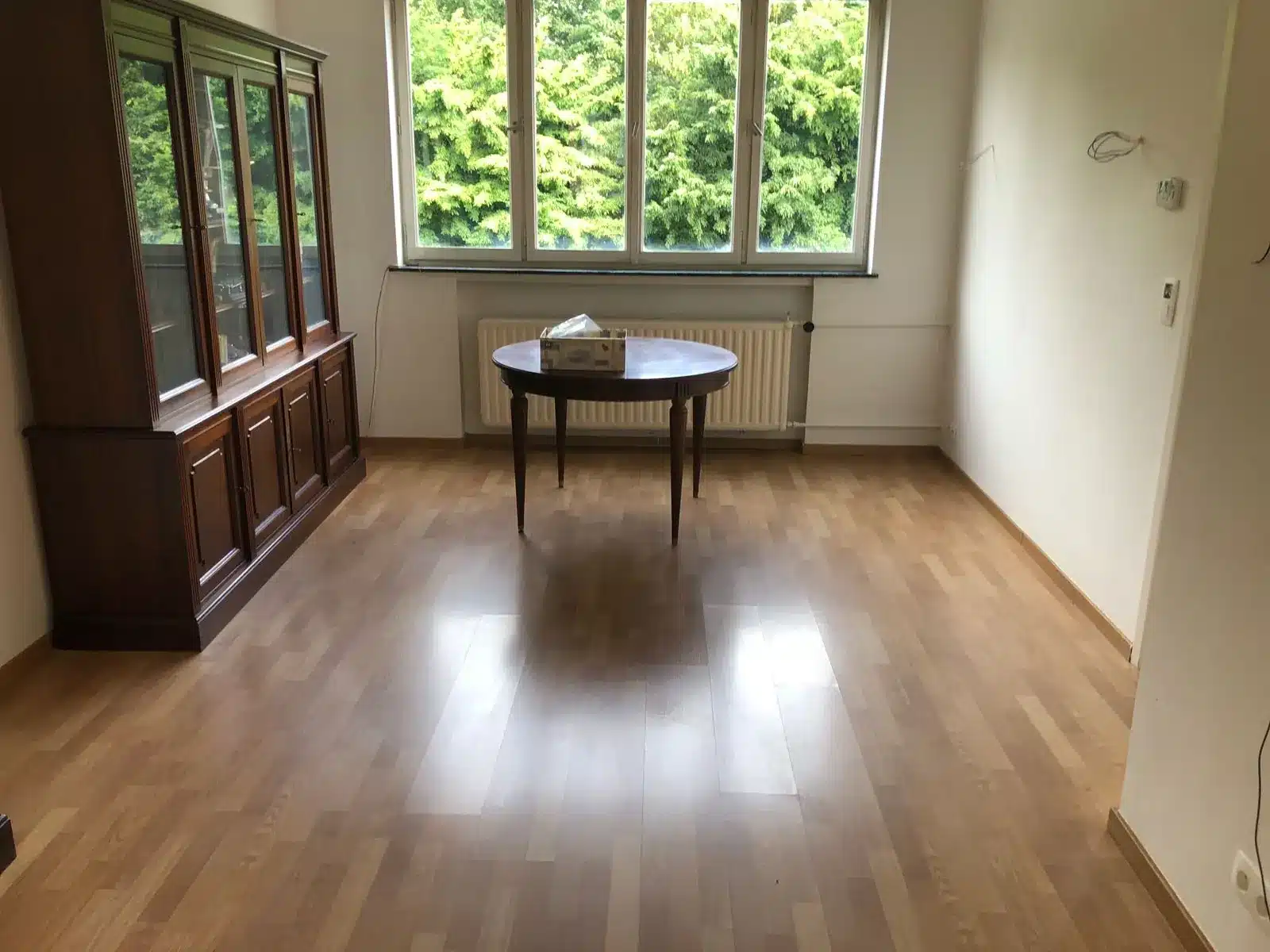 La même pièce vidée et propre, le vaisselier et la table conservés pour la famille