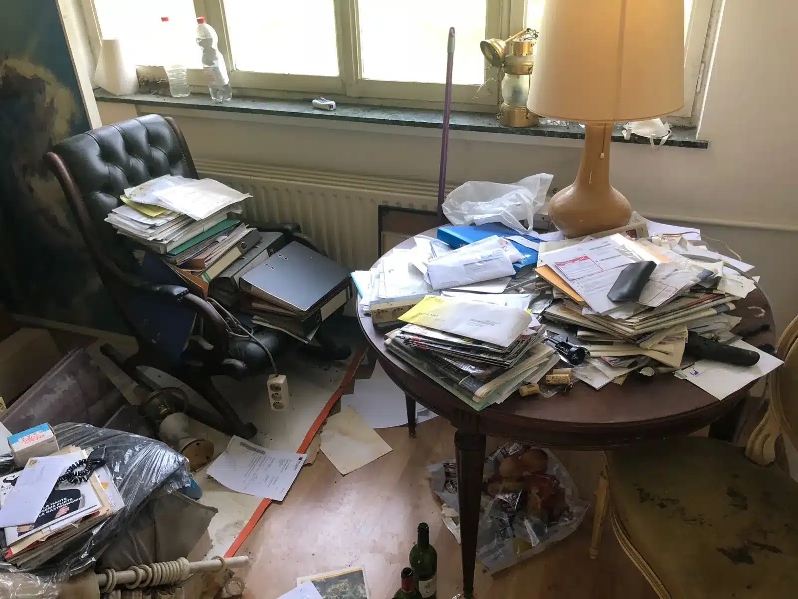 Bureau envahi de papiers et de sacs dans l'appartement d'un parent décédé à Ixelles