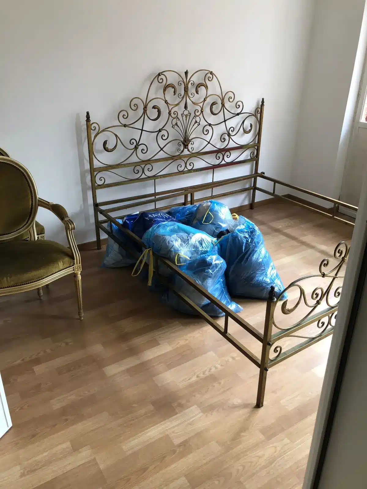 Le même lit en fer forgé dégagé, prêt à être récupéré par la famille