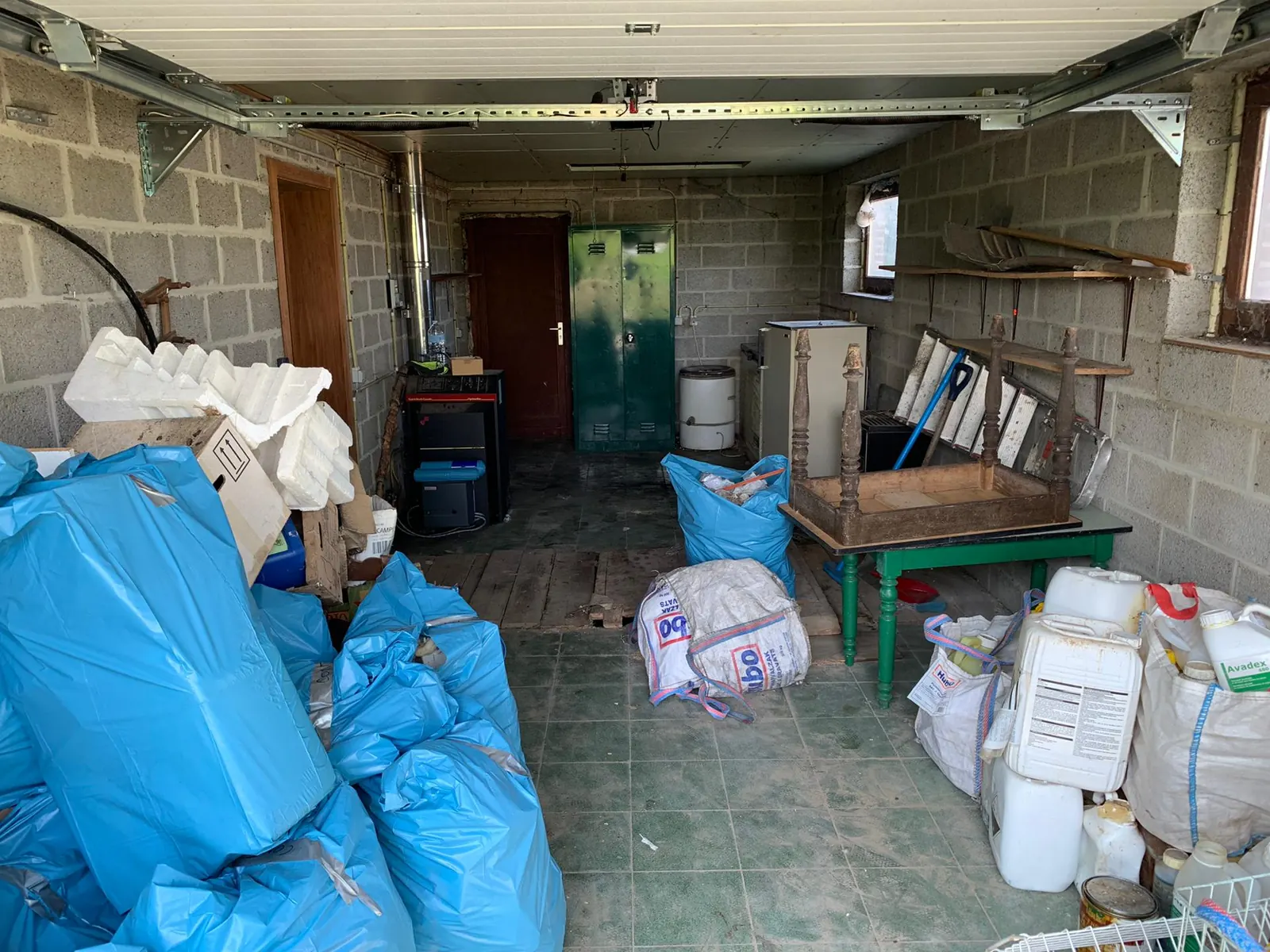 Garage rempli de sacs et d'objets avant le débarras à Nivelles
