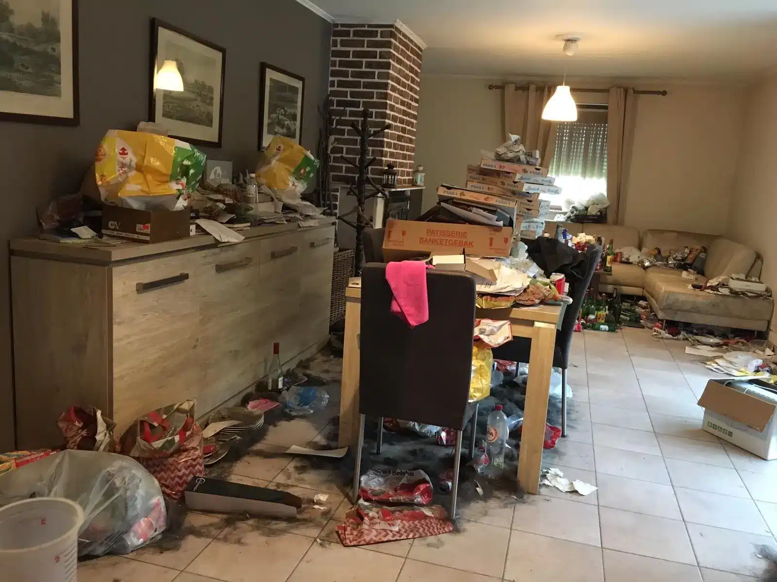 Salle à manger encombrée de sacs et de cartons dans une maison à Obourg